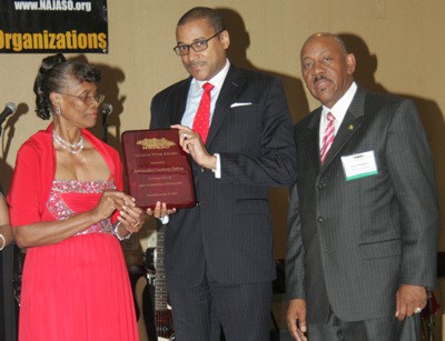 Jamaica’s Ambassador to the United Nations, Courtney Rattray (center) accepts the Lignum Vitae award from Vice President of NAJASO Eastern Region, Ms. Sadie Campbell. Looking on at right is President of the National Association of Jamaican and Supportive Organizations (NAJASO), Rick Nugent.  (Photo Credit: Derrick Scott)