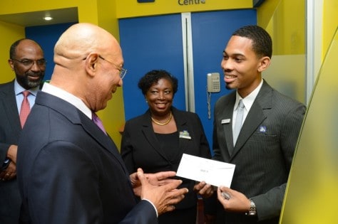 Governor-General, His Excellency Sir Patrick Allen (foreground) gets banking advice from  Bryan Robinson (right), Member Service Representative from the Half-Way-Tree Branch of Jamaica National Building Society(JNBS), while Earl Jarrett (left), JNBS General Manager, and   Jennifer Clarke Twiddle, JNBS Business Relationship & Sales Advisor look on. 