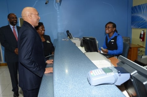 Governor-General, His Excellency Sir Patrick Allen (foreground) converses with Alecia Clarke (right), JNBS Member Service Officer, along Earl Jarrett (left), JNBS General Manager, and   Jennifer Clarke Twiddle, JNBS Business Relationship & Sales Advisor in the JNBS Half-Way-Tree Branch, on a tour of the JNBS headquarters. 