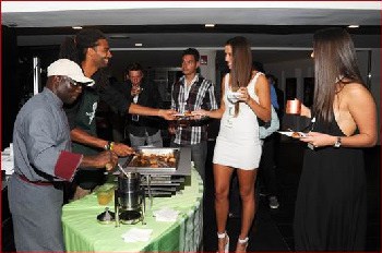 Jamaica’s professional tennis star Dustin Brown (2nd left) joins Chef Paul Evans of Secrets Resort & Spa in serving up his mouth-watering Chicken Roullete stuffed with pumpkin and glazed with jerk sauce at the Get All Right Lounge. 
