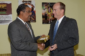 Minister of Tourism and Entertainment, Hon. Dr. Wykeham McNeill (left), accepts a gift from the White House from Mr. Cleveland Charles, Political and Economic Affairs Counsellor.
