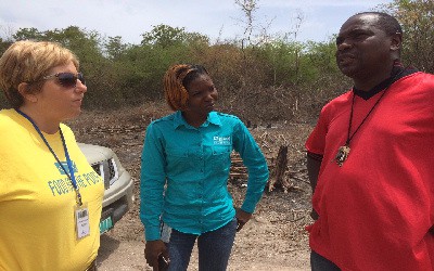 Rebecca Harper, Manager of Agriculture and Fisheries at Food for the Poor and Patrice Smith-Sterling, Grants and Finance Specialist at the Digicel Foundation pay keen attention to Gary Foster, Chairman of Upliftment Jamaica as he discusses the work being done at the site in White Horses, St. Thomas.