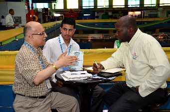 "Representatives from Canadian company Dattani Wholesalers (left) speaks to Earle McEwan of  Wynlee Group of Companies during a business meeting about Wynlee's array of locally made products at Expo Jamaica 2014."