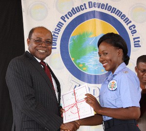 Minister of Tourism, Hon. Edmund Bartlett (left) presents Janique Chambers with her certificate at the closing ceremony for the new District Constables Training Programme. The ceremony was held in honor of the first batch of graduates from the programme at the National Police College of Jamaica training facility at Twickenham Park, St. Catherine on Tuesday, July 19, 2016. 