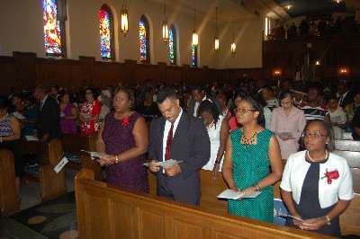 Charge d’Affairs of the Embassy of Jamaica, Mrs. Marsha Coore Lobban (left) along with her husband, Lt Colonel Dillion Lobban, Minister Council at the Embassy of Jamaica Mrs Ariel Bowen and Jamaica’s Alternate representative to Organization of American States (OAS), Mrs, Julia Hyatt joins the large congregation of Jamaicans and friends of Jamaica in a hymn of praise at the service of thanksgiving to mark Jamaica’s 54th year of independence on Sunday, August 7 at the Dumbarton chapel, Howard University School of Law in Washington DC.  Photo by Derrick Scott