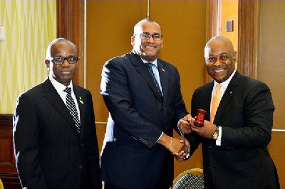 New Caribbean Tourism Organization Chairman Obie Wilchcombe of the Bahamas (right) receives the gavel from his predecessor Richard Sealy of Barbados. Also in photograph, CTO secretary general Hugh Riley (left)