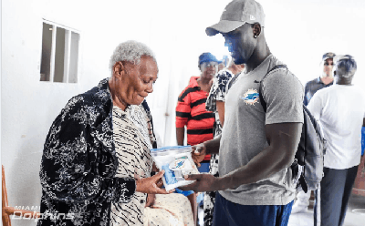 Miami Dolphins player Michael Thomas assists in handing out needed supplies in The Bahamas.