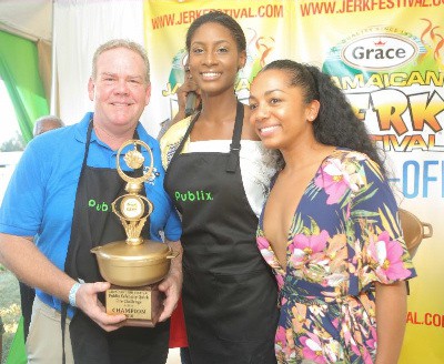Local 10 TV news anchor Todd Tongen holds his Gold Dutch Pot as winner of the Celebrity Quick Fire Challenge over Miss Jamaica World 2016 Ashie Barrett (center) with well wisher AnushcaMai Walton Bunting at the Publix Pavilion 