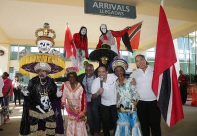 Patrick Hypeman Alexis surrounded by customers, Carnival Characters and Caribbean Airlines employees & Crew