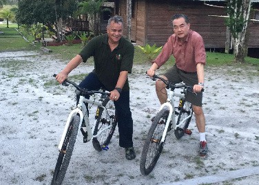 Minister Wang Yi with Roraima CEO Capt. Gerry Gouveia at Arrowpoint Nature Resort in Guyana bike riding at Arrowpoint Nature Resort in Guyana.