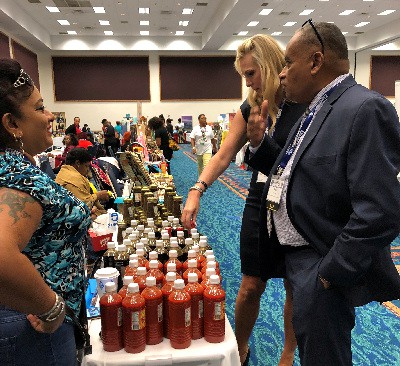 FDA’s Kim Prenter in discussion with Anne Peters Bristol of Anne’s Products while Guyanese American Chamber of Commerce president Wesley Kirton listens.