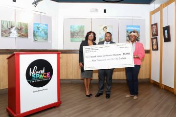 Haitian Consul General Stéphane Gilles (center) presents a $5,000 check to Island SPACE Board Member Tamara Philippeaux (left) and Executive Director Calibe Thompson.