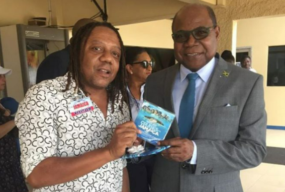 Tourism Minister, Hon. Edmund Bartlett, is presented with an album by music producer Sean Edwards.
