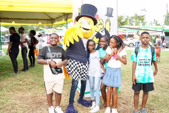 Mr. Chicken, posing with excited children at the Montego Bay Jerk & Food Festival